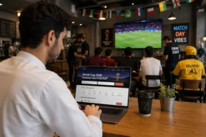 Beginner job seeker searching for World Cup 2026 jobs in the Gulf on a laptop inside a café with football fans, event staff, café workers, and delivery support in the background